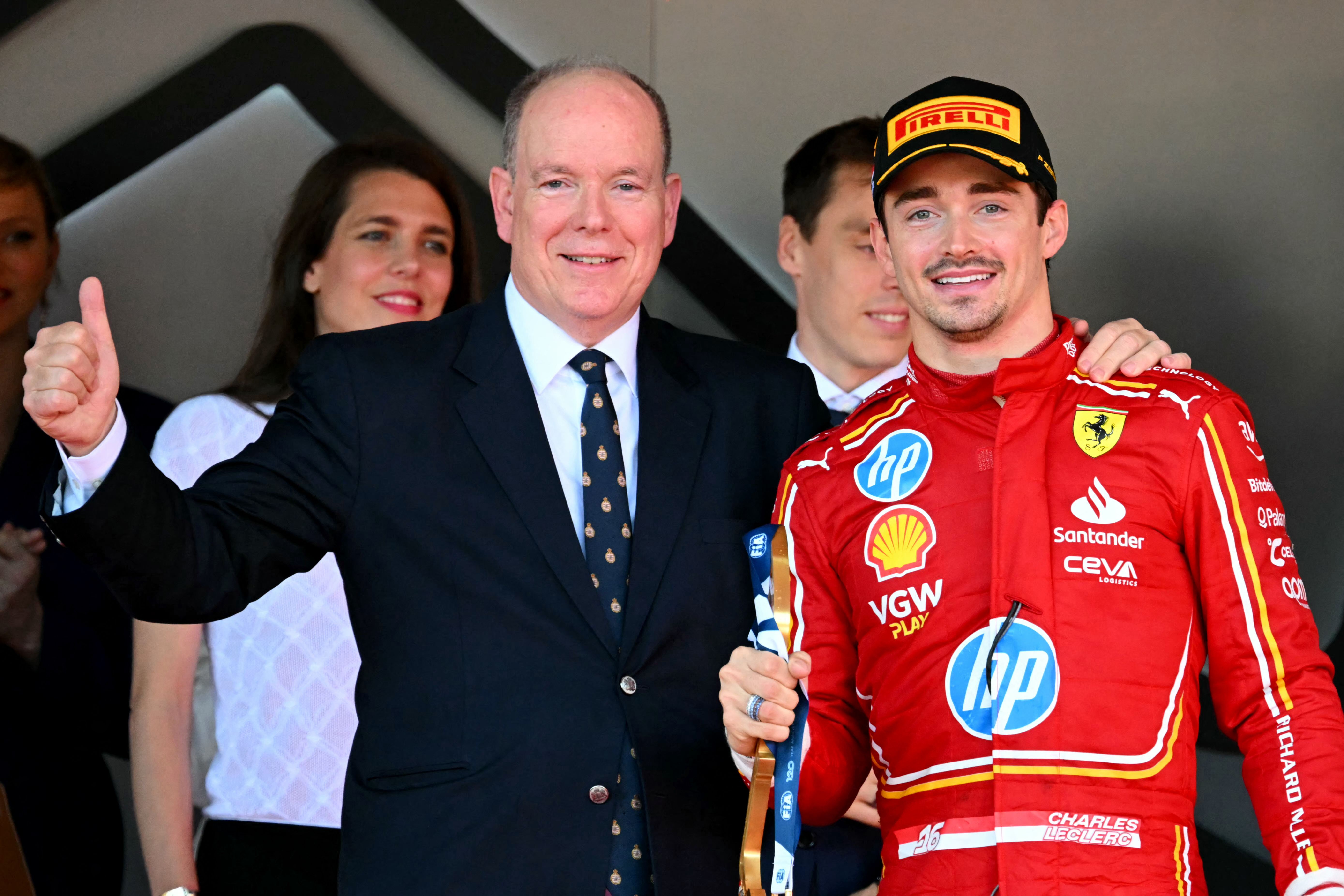 Race winner Ferrari's Monegasque driver Charles Leclerc (R) poses with Prince Albert II of Monaco (L) on the podium after the Formula One Monaco Grand Prix on May 26, 2024 at the Circuit de Monaco. (Photo by NICOLAS TUCAT / AFP)