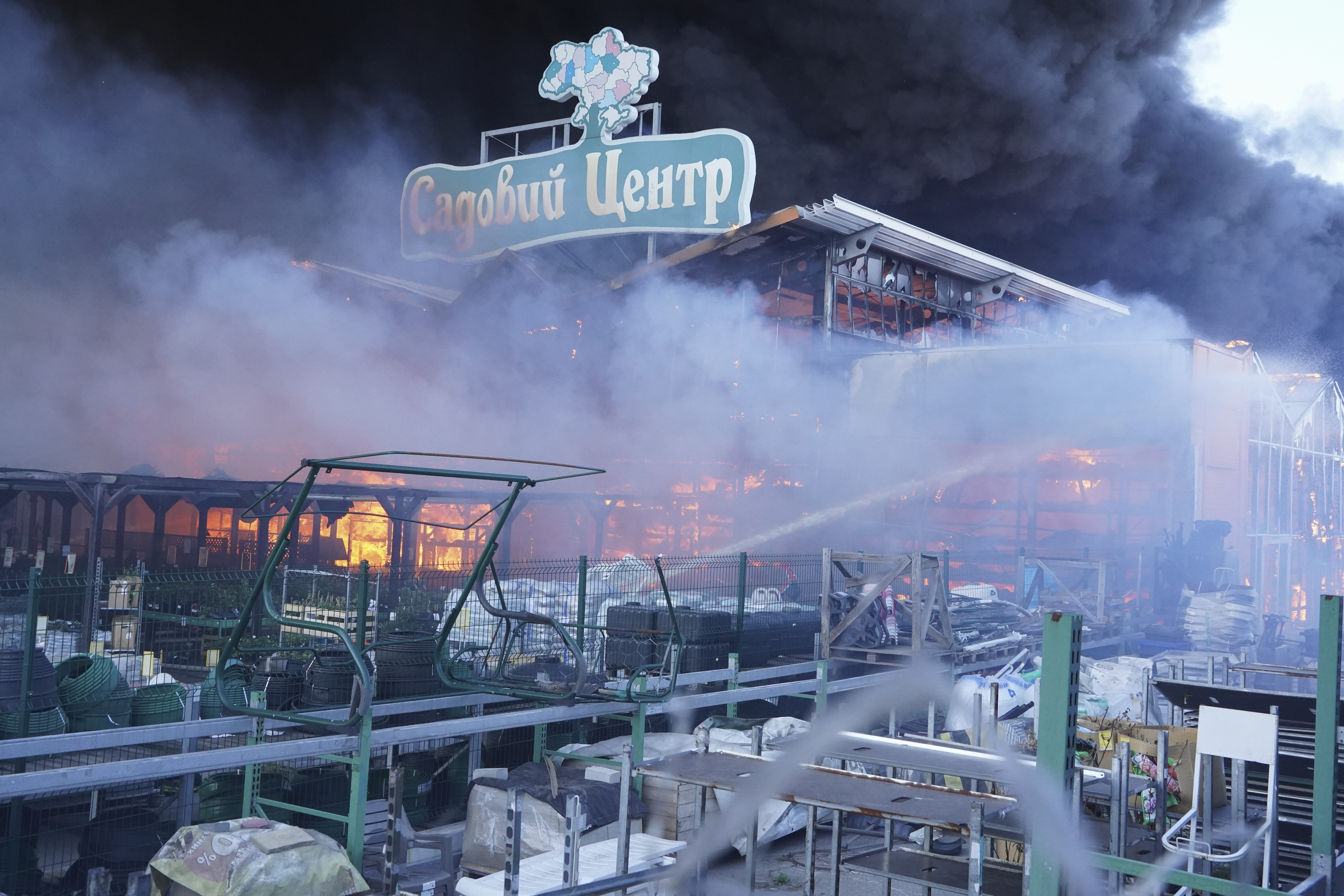 Firefighters put out a fire after two guided bombs hit a large construction supplies store in Kharkiv, Ukraine, Saturday, May 25, 2024. Writing reads \"Garden Center\". (AP Photo/Andrii Marienko)