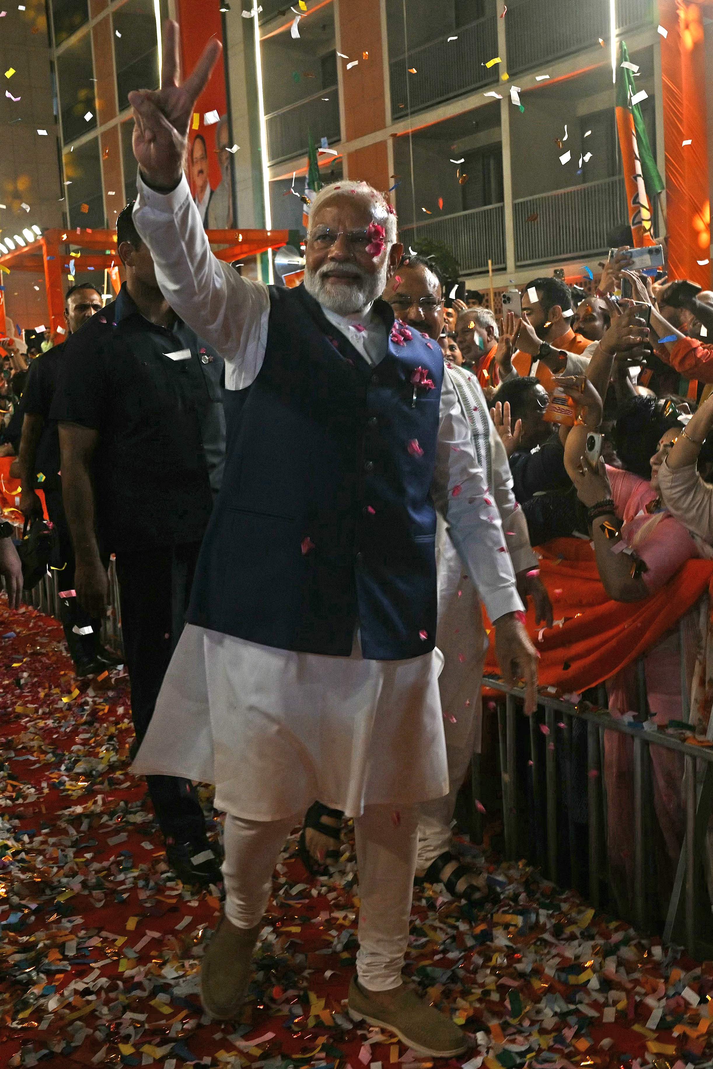 Indias Prime Minister Narendra Modi (C) flashes victory sign as he arrives at the Bharatiya Janata Party (BJP) headquarters to celebrate the partys win in country's general election, in New Delhi on June 4, 2024. Modi claimed election victory for his party and its allies on June 4, but the opposition said they had "punished" the ruling party to confound predictions and reduce their parliamentary majority. (Photo by ARUN SANKAR / AFP)