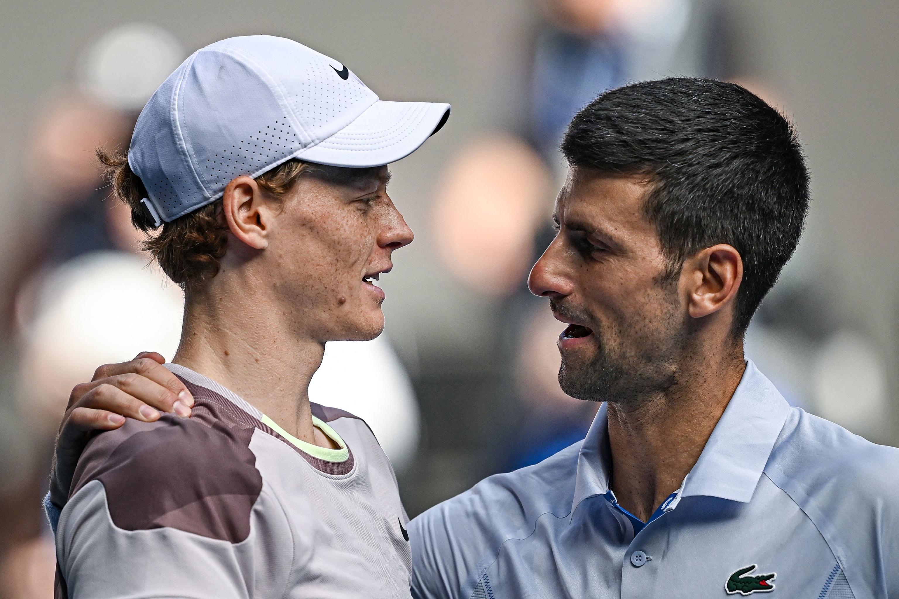 TOPSHOT - Italy's Jannik Sinner greets Serbia's Novak Djokovic (R) after victory in their men's singles semi-final match on day 13 of the Australian Open tennis tournament in Melbourne on January 26, 2024. (Photo by Lillian SUWANRUMPHA / AFP) / -- IMAGE RESTRICTED TO EDITORIAL USE - STRICTLY NO COMMERCIAL USE --