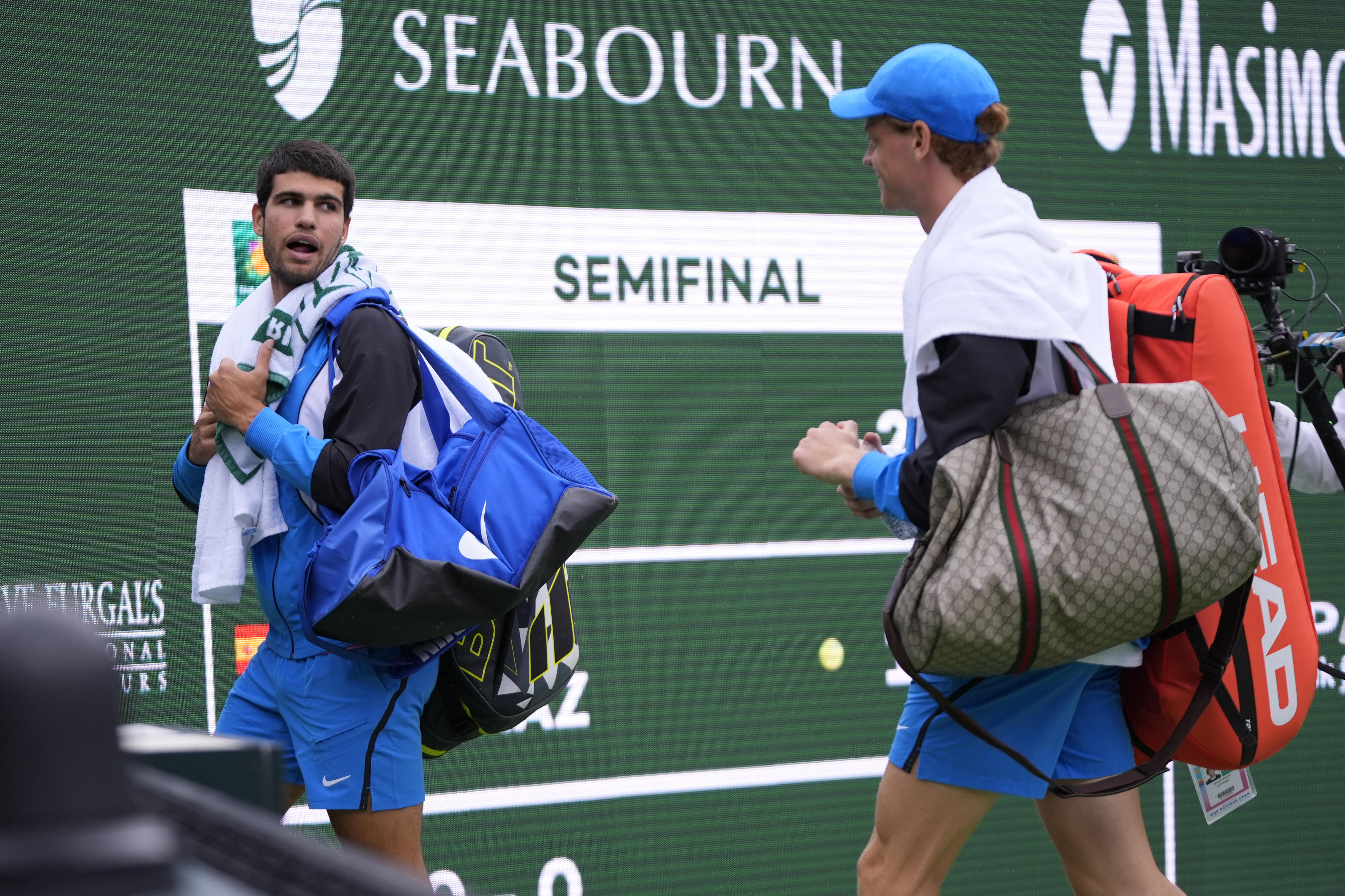 Carlos Alcaraz, of Spain, left, and Jannik Sinner, of Italy, leave the court during a rain delay in their semifinal match at the BNP Paribas Open tennis tournament, Saturday, March 16, 2024, in Indian Wells, Calif. (AP Photo/Mark J. Terrill)
