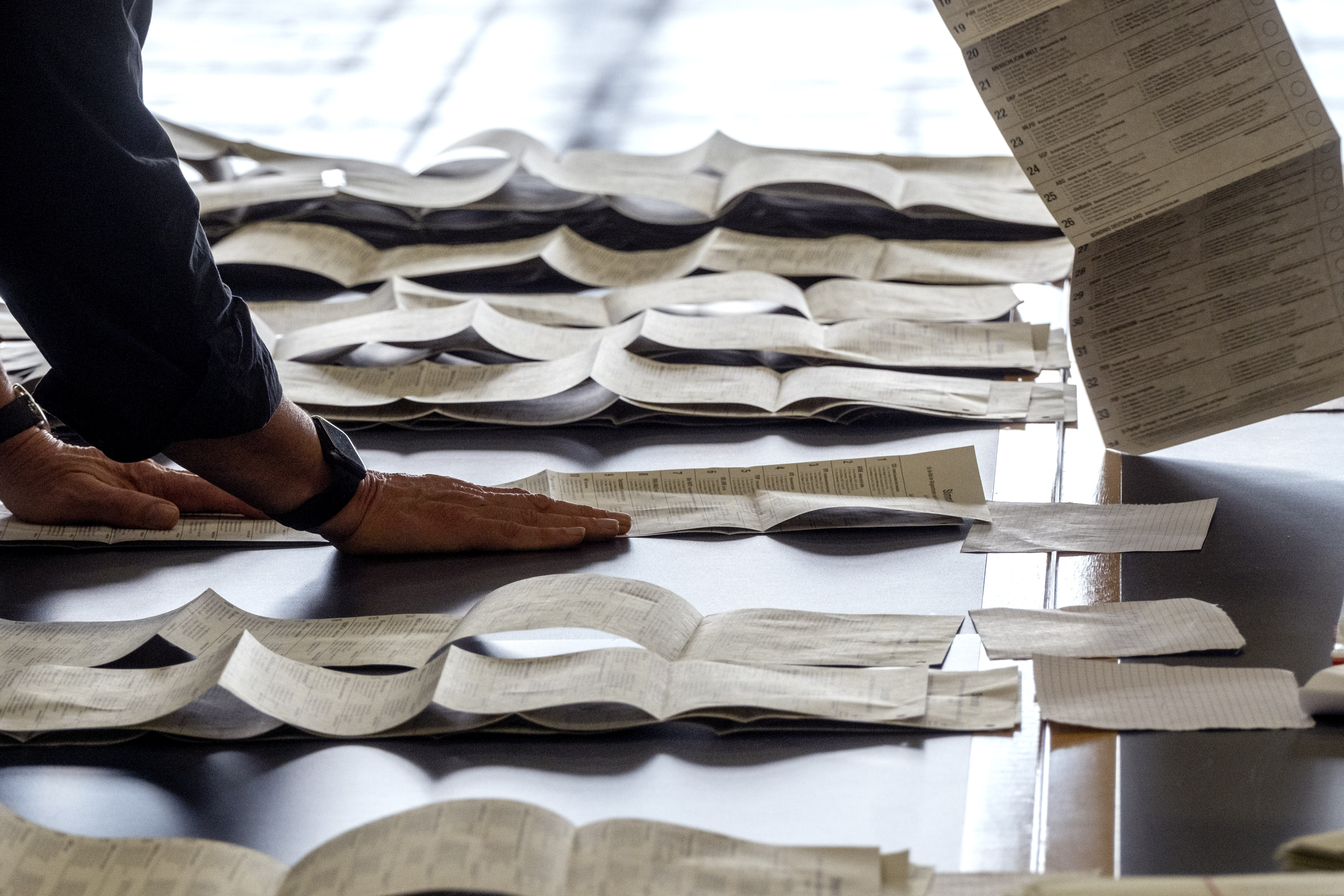 Elections helpers count the postal ballots for the European elections in a hall of the fair sound in Frankfurt, Germany, Sunday, June 9, 2024. (AP Photo/Michael Probst)