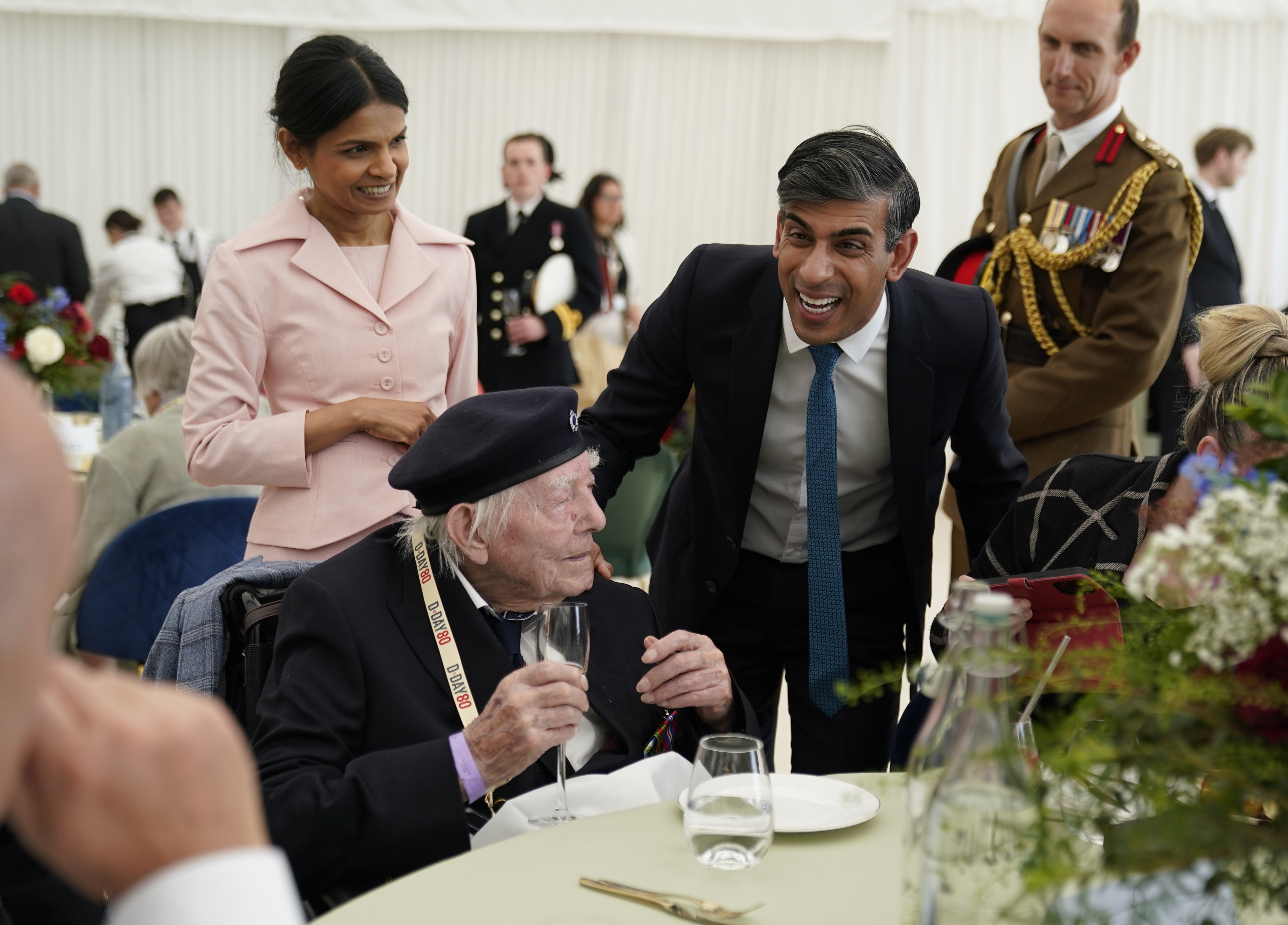 PORTSMOUTH, ENGLAND - JUNE 5: Prime Minister Rishi Sunak and wife Akshata Murty meet 98-year-old veteran Frank Cooper during a lunch for veterans and VIPs following the UK's national commemorative event for the 80th anniversary of D-Day, hosted by the Ministry of Defence on Southsea Common on June 5, 2024 in Portsmouth, England. King Charles III and Queen Camilla lead the commemorative events in Portsmouth ahead of the actual 80th Anniversary of D-Day on June 6th. Veterans, VIP Guests and school children are attending an event on Southsea Common. Portsmouth was where tens of thousands of troops set off to Normandy to participate in Operation Overlord. They established a foothold on the French coast and advanced to liberate northwest Europe. (Photo by Andrew Matthews - Pool/Getty Images)