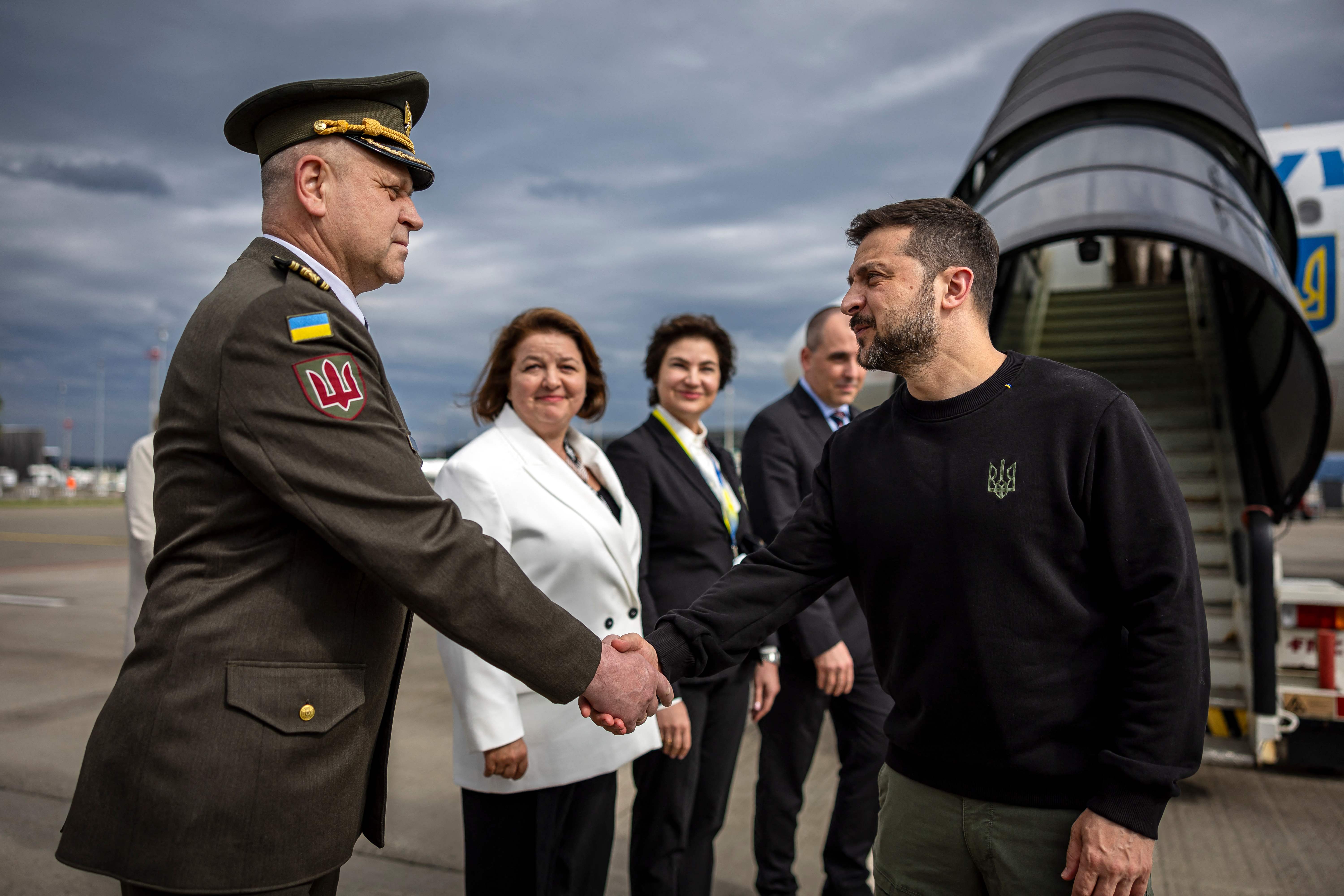 Ukraine's President Volodymyr Zelensky (R) is welcomed by a Ukranian military personnel and Ukraine's Ambassador to Switzerland Iryna Wenediktowa (C) as he arrives at the Zurich airport on June 14, 2024, ahead of the Ukraine Peace Summit in Switzerland. World leaders from countries around the world will gather in the luxury Burgenstock resort, central Switzerland this weekend to try to work out a way towards a peace process for Ukraine -- albeit without Russia. (Photo by MICHAEL BUHOLZER / POOL / AFP)