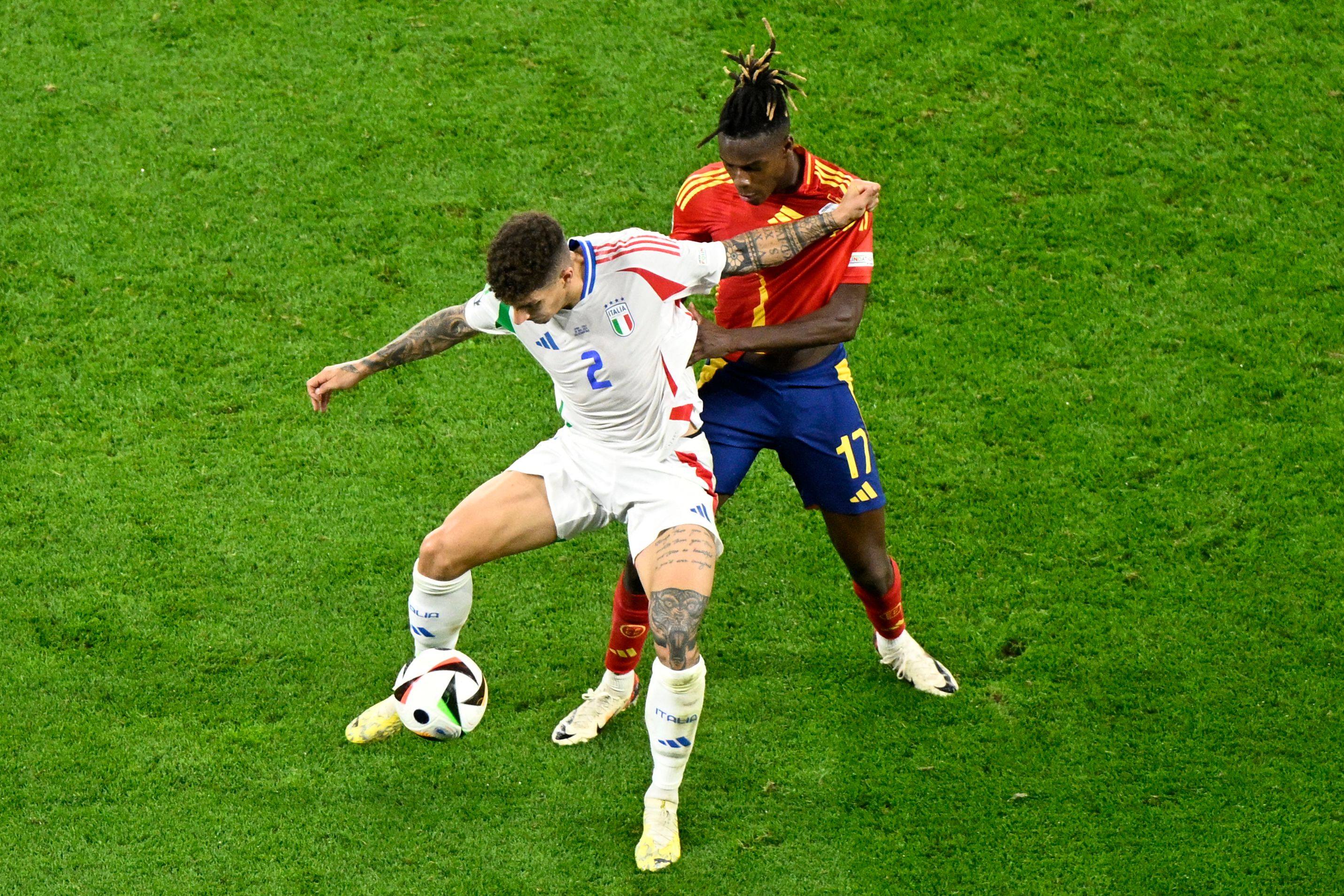 Italy's defender #02 Giovanni Di Lorenzo (L) fights for the ball with Spain's midfielder #17 Nico Williams during the UEFA Euro 2024 Group B football match between Spain and Italy at the Arena AufSchalke in Gelsenkirchen on June 20, 2024. (Photo by INA FASSBENDER / AFP)