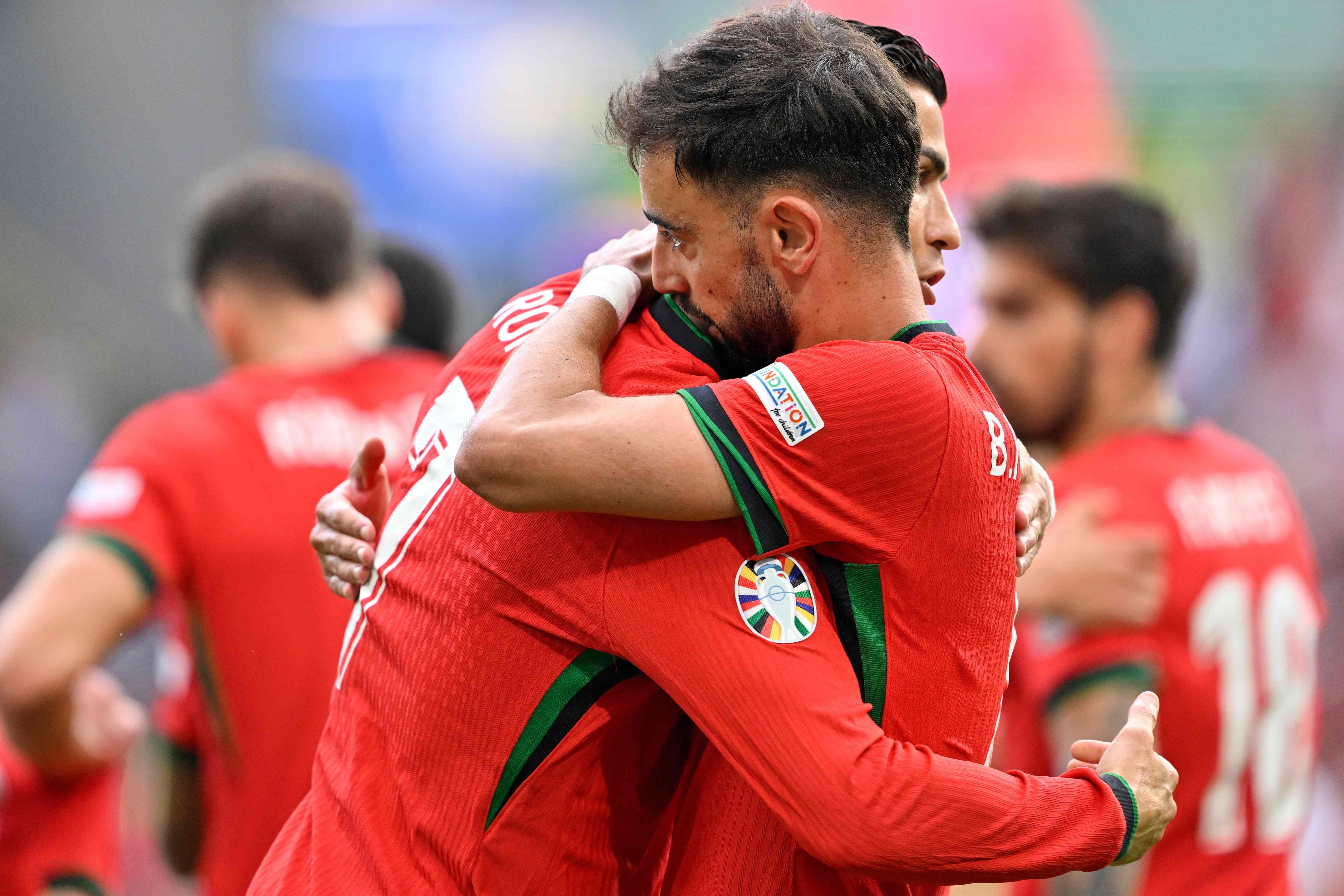 TOPSHOT - Portugal's midfielder #08 Bruno Fernandes (R) celebrates with Portugal's forward #07 Cristiano Ronaldo (L) after scoring his team's third goal during the UEFA Euro 2024 Group F football match between Turkey and Portugal at the BVB Stadion in Dortmund on June 22, 2024. (Photo by INA FASSBENDER / AFP)