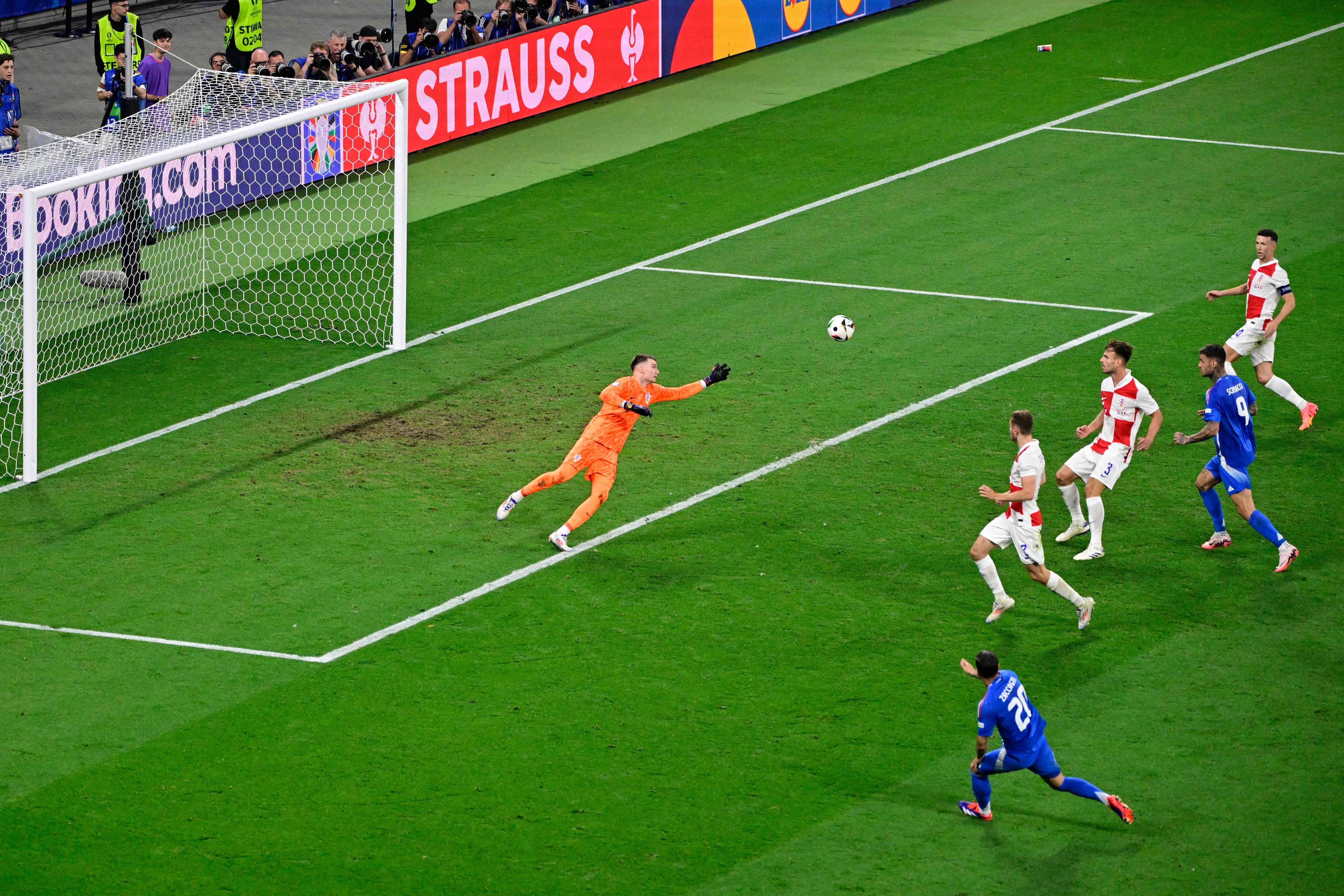 Italy's forward #20 Mattia Zaccagni (down, R) shoots and scores a goal against Croatia's goalkeeper #01 Dominik Livakovic during the UEFA Euro 2024 Group B football match between Croatia and Italy at the Leipzig Stadium in Leipzig on June 24, 2024. (Photo by JOHN MACDOUGALL / AFP)