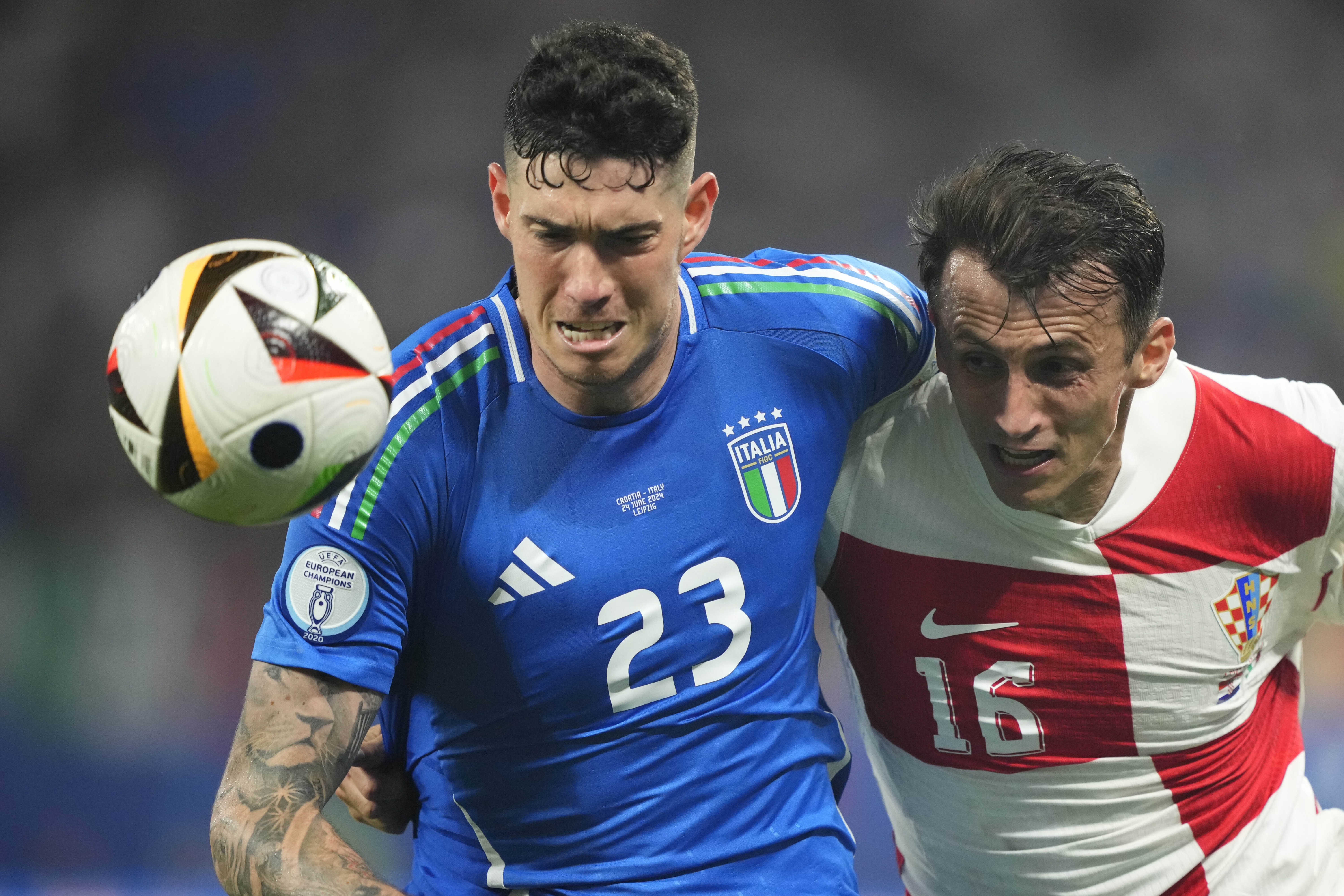 Italy's Alessandro Bastoni, left, challenges for the ball with Croatia's Ante Budimir during a Group B match between Croatia and Italy at the Euro 2024 soccer tournament in Leipzig, Germany, Monday, June 24, 2024. (AP Photo/Ebrahim Noroozi)
