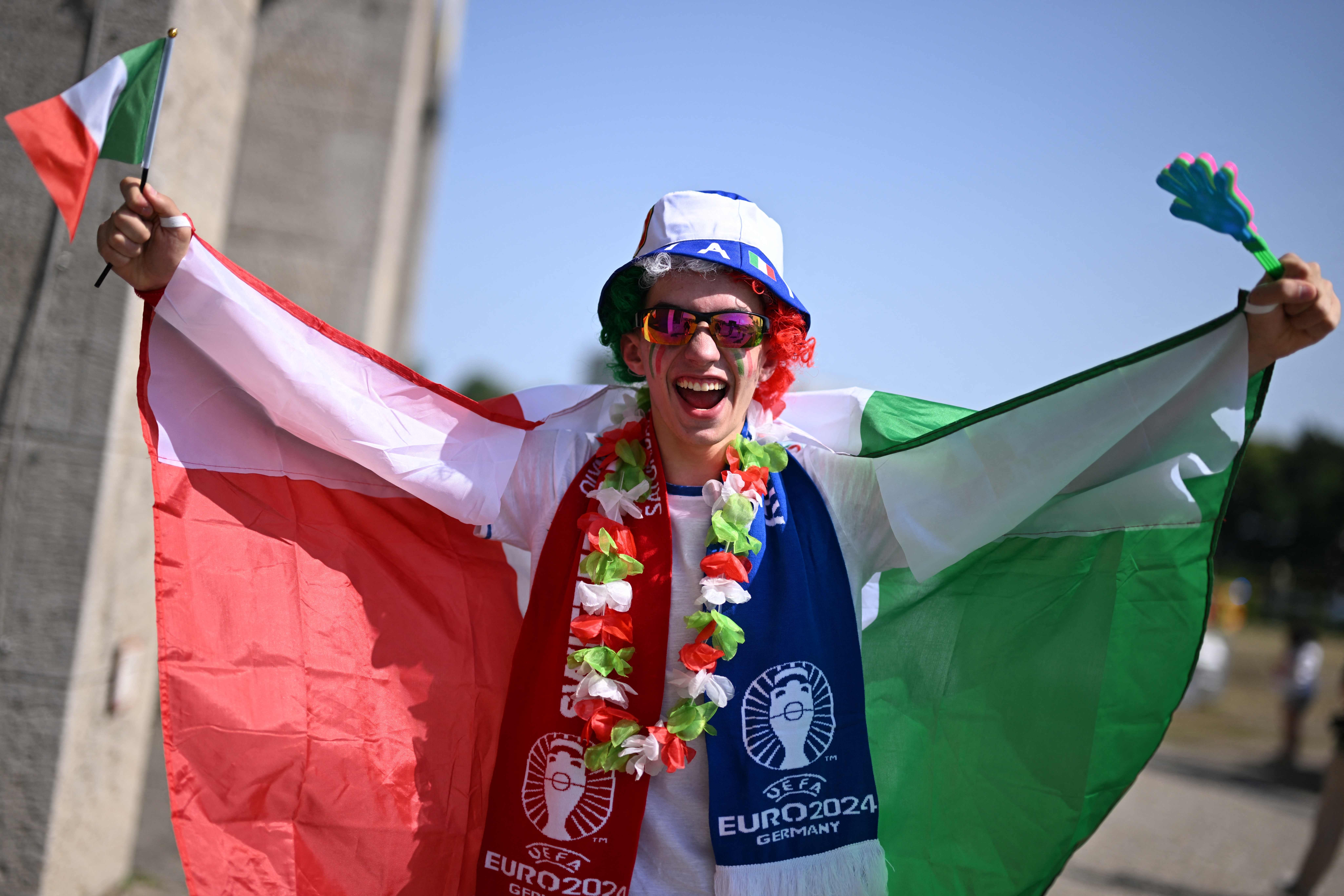 An Italian supporter poses with the Italian flag ahead of the UEFA Euro 2024 round of 16 football match between Switzerland and Italy at the Olympiastadion Berlin in Berlin on June 29, 2024. (Photo by Kirill KUDRYAVTSEV / AFP)