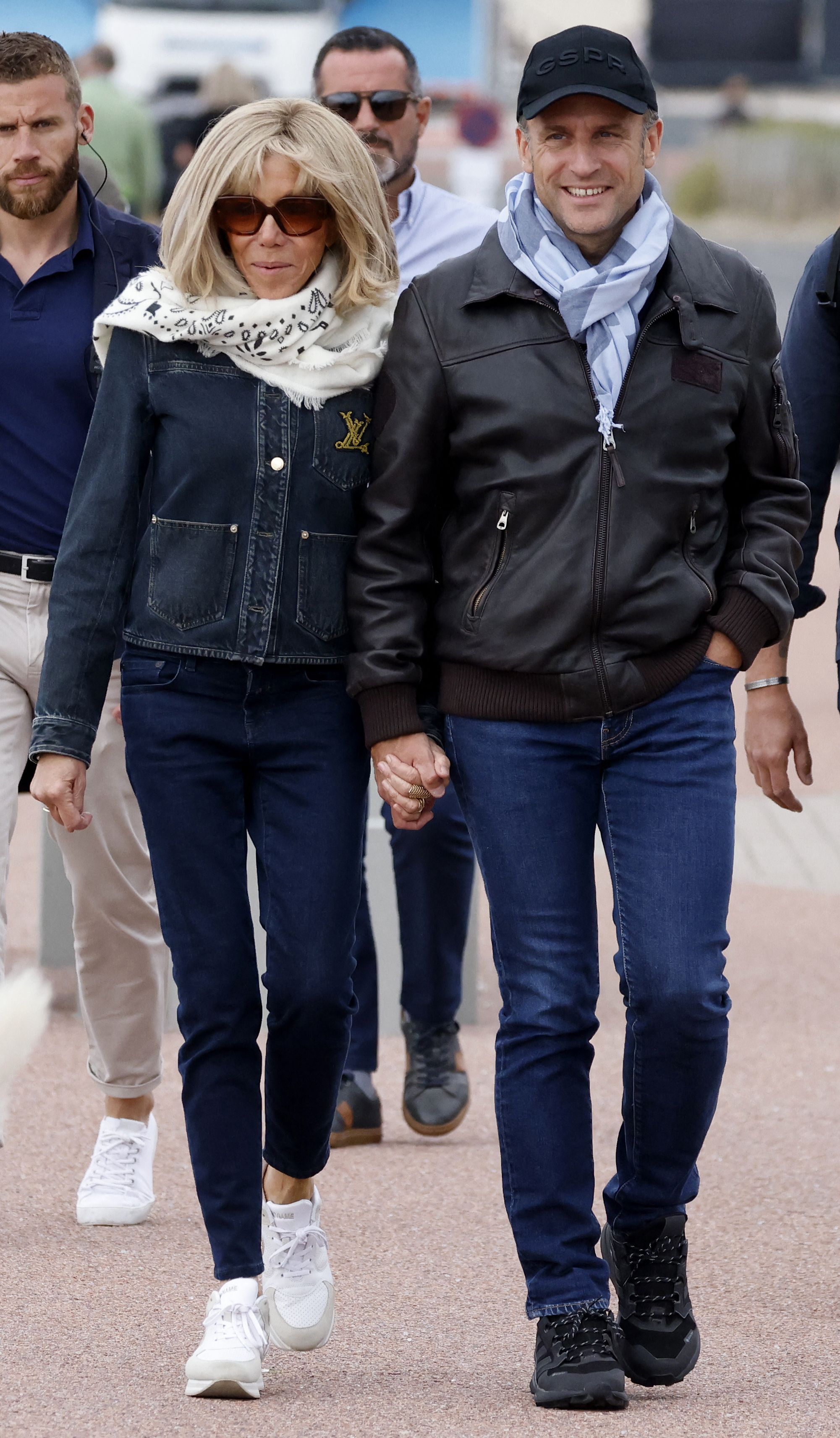 France's President Emmanuel Macron (R) and his wife first lady Brigitte Macron (L) walk along the beach during an air show in Le Touquet-Paris-Plage, northern France, on June 29, 2024. (Photo by Ludovic MARIN / AFP)