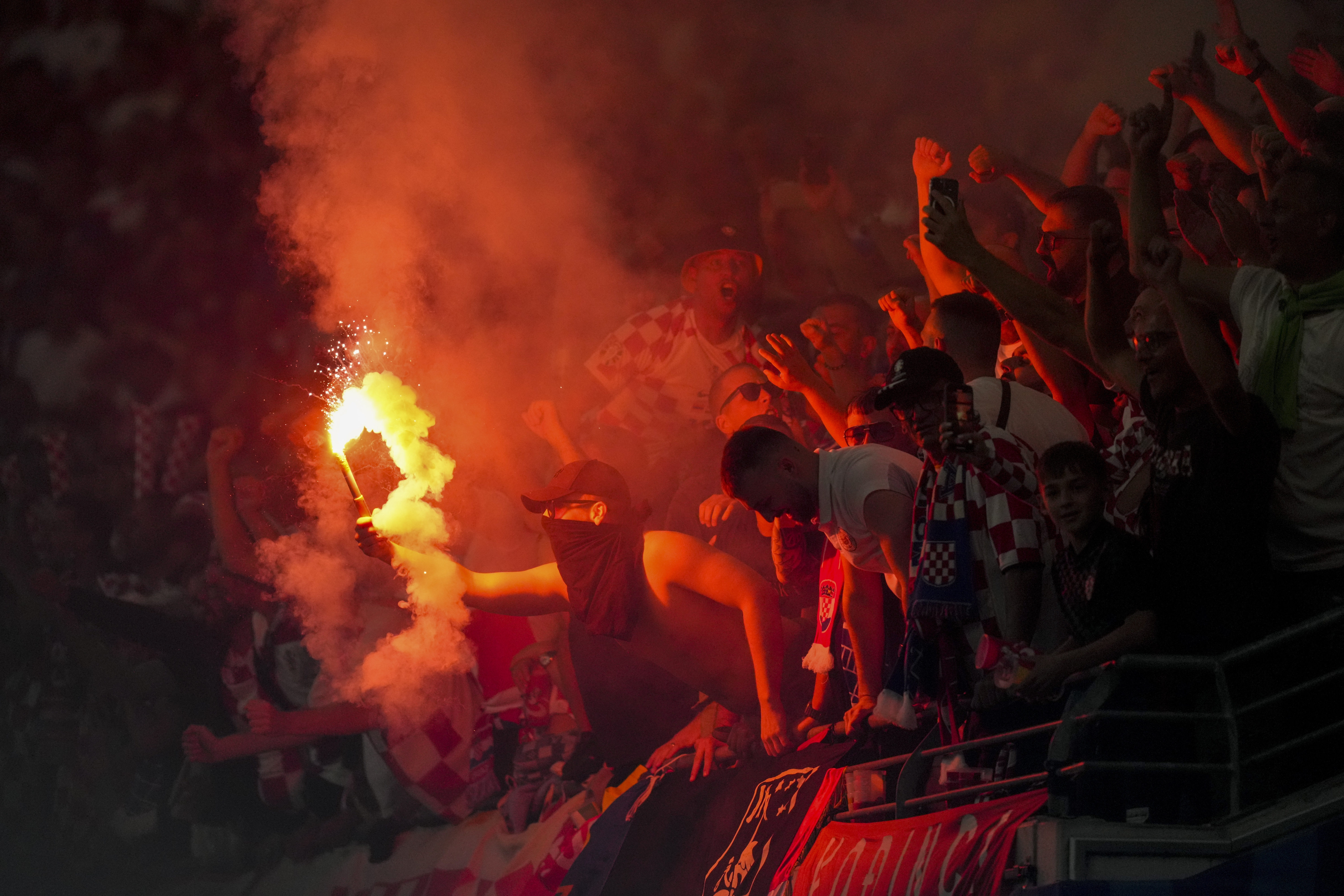 Croatia's soccer team supporters light a flare during a Group B match between Croatia and Italy at the Euro 2024 soccer tournament in Leipzig, Germany, Monday, June 24, 2024. (AP Photo/Sunday Alamba)