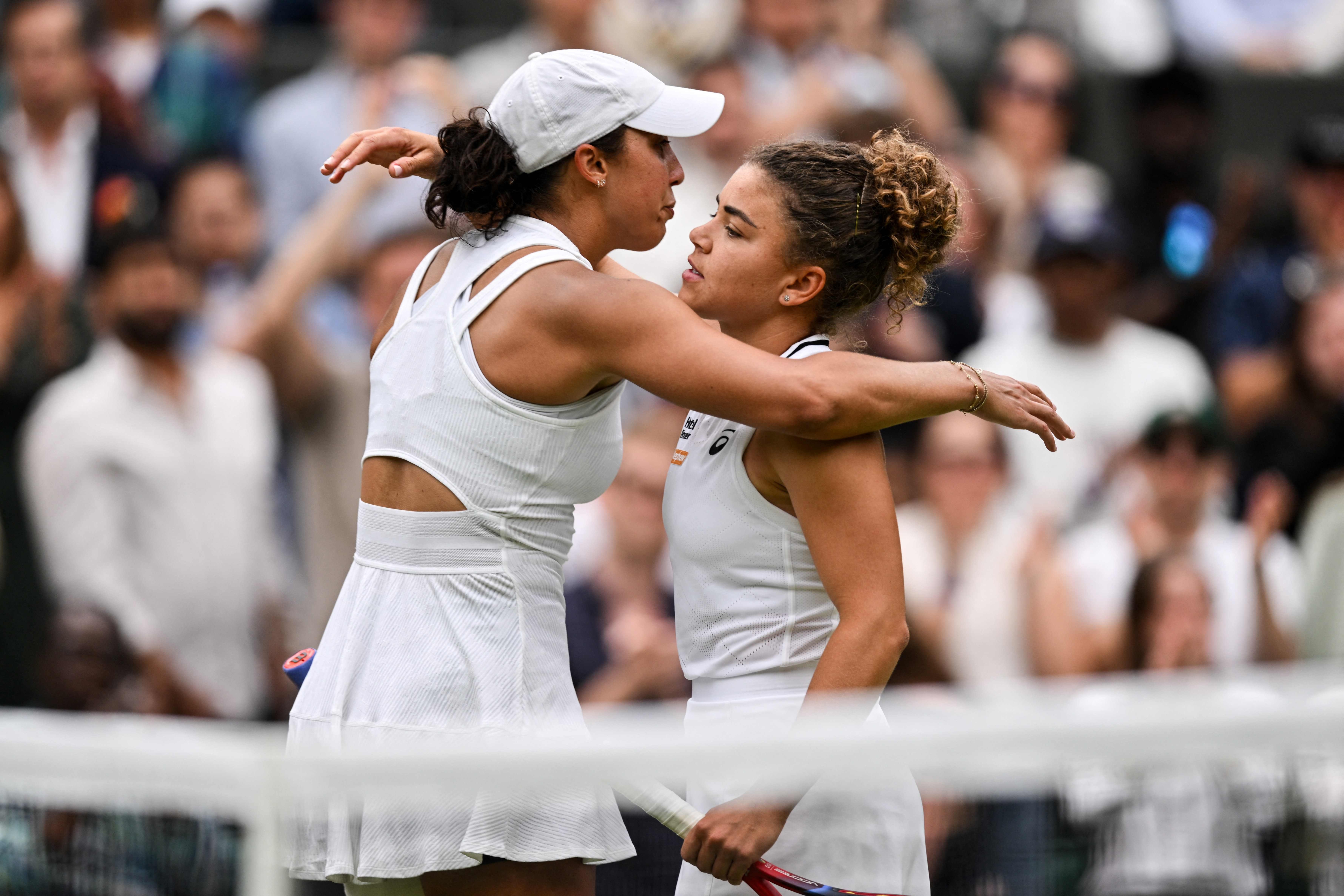 US player Madison Keys (L) hugs winner Italy's Jasmine Paolini (R) after retiring from their women's single match following a thigh injury on the seventh day of the 2024 Wimbledon Championships at The All England Lawn Tennis and Croquet Club in Wimbledon, southwest London, on July 7, 2024. (Photo by ANDREJ ISAKOVIC / AFP) / RESTRICTED TO EDITORIAL USE