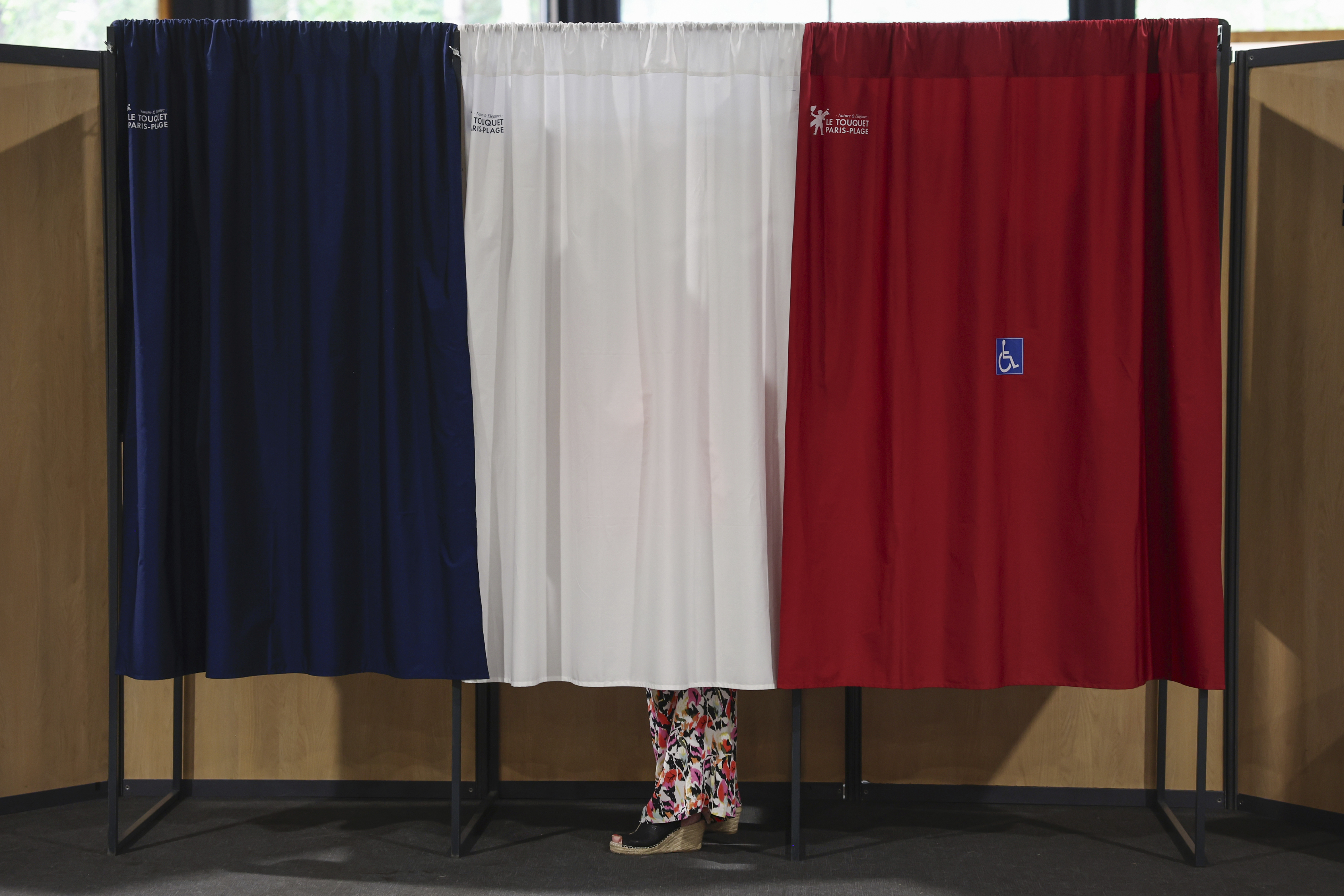 A voter stands in the polling booth during the second round of the legislative elections in Le Touquet-Paris-Plage, northern France, Sunday July 7 2024. Voting has begun in mainland France on Sunday in pivotal runoff elections that could hand a historic victory to Marine Le Pen's far-right National Rally and its inward-looking, anti-immigrant vision ? or produce a hung parliament and political deadlock. (Mohammed Badra, Pool via AP)