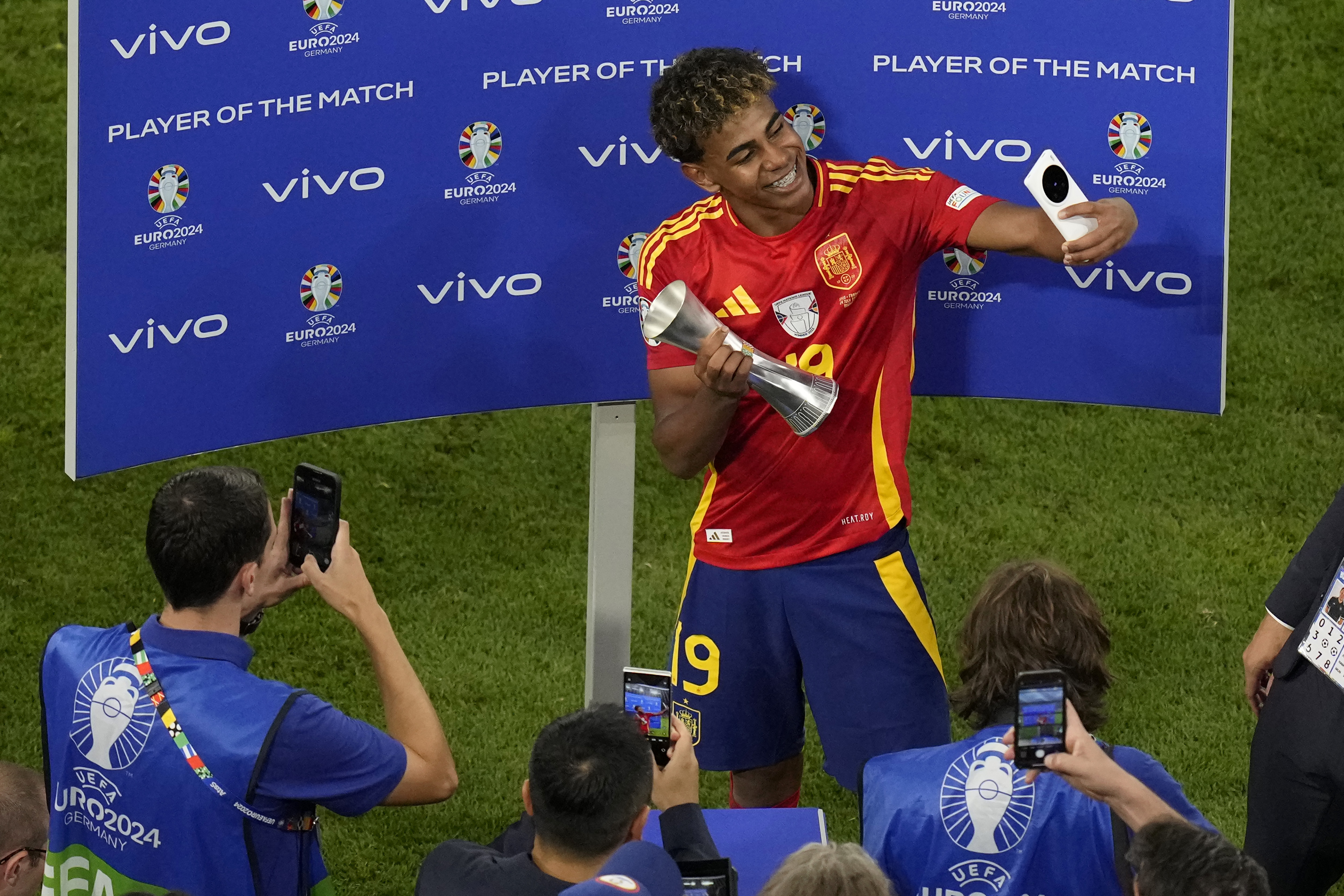 Spain's Lamine Yamal receives the trophy for the best player of the match, at the end of a semifinal match between Spain and France at the Euro 2024 soccer tournament in Munich, Germany, Tuesday, July 9, 2024. (AP Photo/Ariel Schalit)