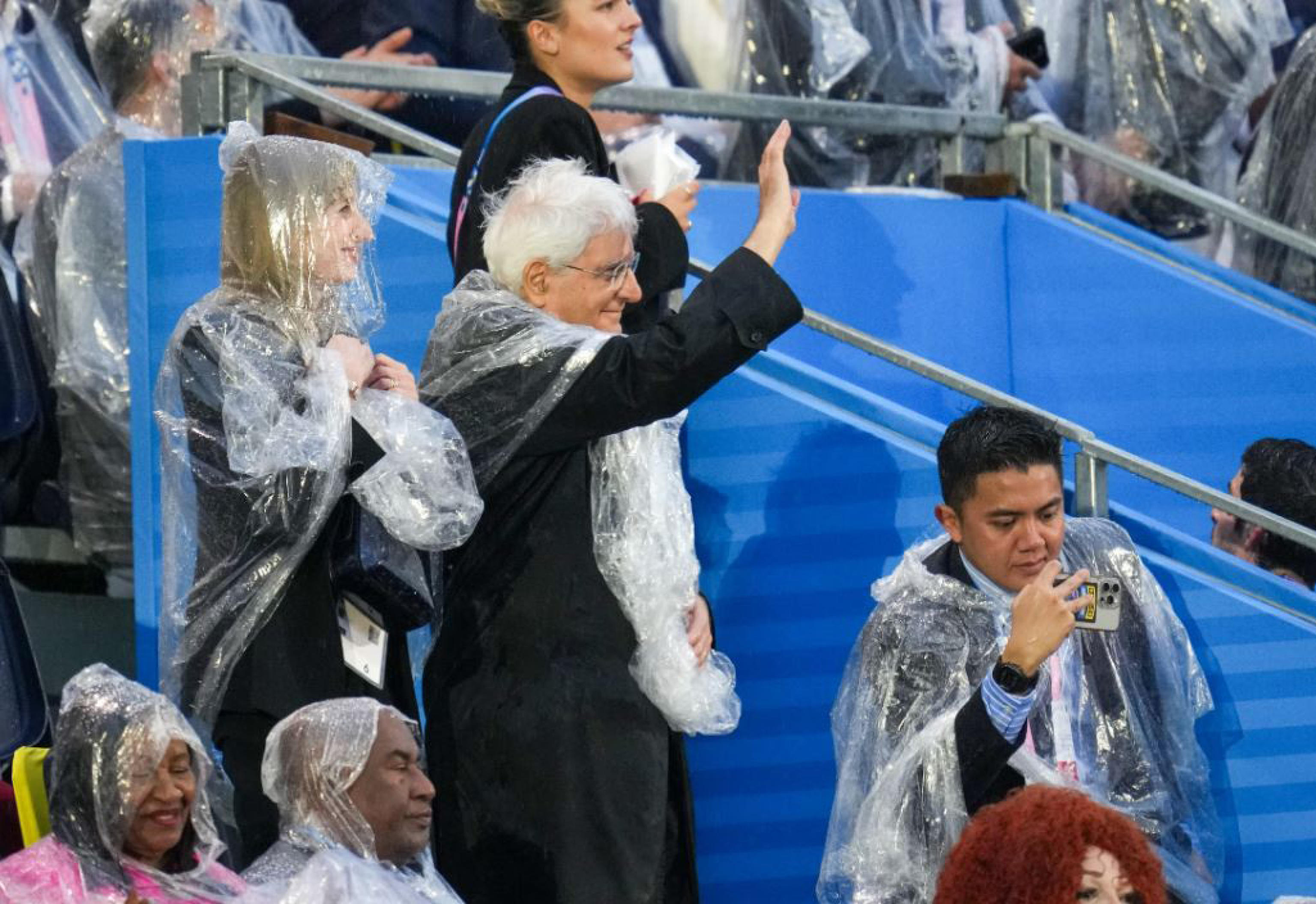 Il Presidente della Repubblica, Sergio Mattarella, presente sugli spalti di Trocadero per la cerimonia di apertura dei Giochi Olimpici, si è alzato in piedi per salutare l'imbarcazione dell'Italia guidata dai due portabandiera, Gianmarco Tamberi e Arianna Errigo. Il Capo dello Stato sta assistendo alla cerimonia nonostante la pioggia incessante che lo ha costretto a indossare un poncho, Parigi, 26 luglio 2024./// Italian President Sergio Mattarella present in the stands of Trocadero for the opening ceremony of the Olympic Games, stood up to greet the Italian boat led by the two Italian flag bearers, Gianmarco Tamberi and Arianna Errigo. Mattarella is attending the ceremony despite the incessant rain that forced him to wear a poncho, in Paris, France, 26 July 2024. ANSA/ STRINGER