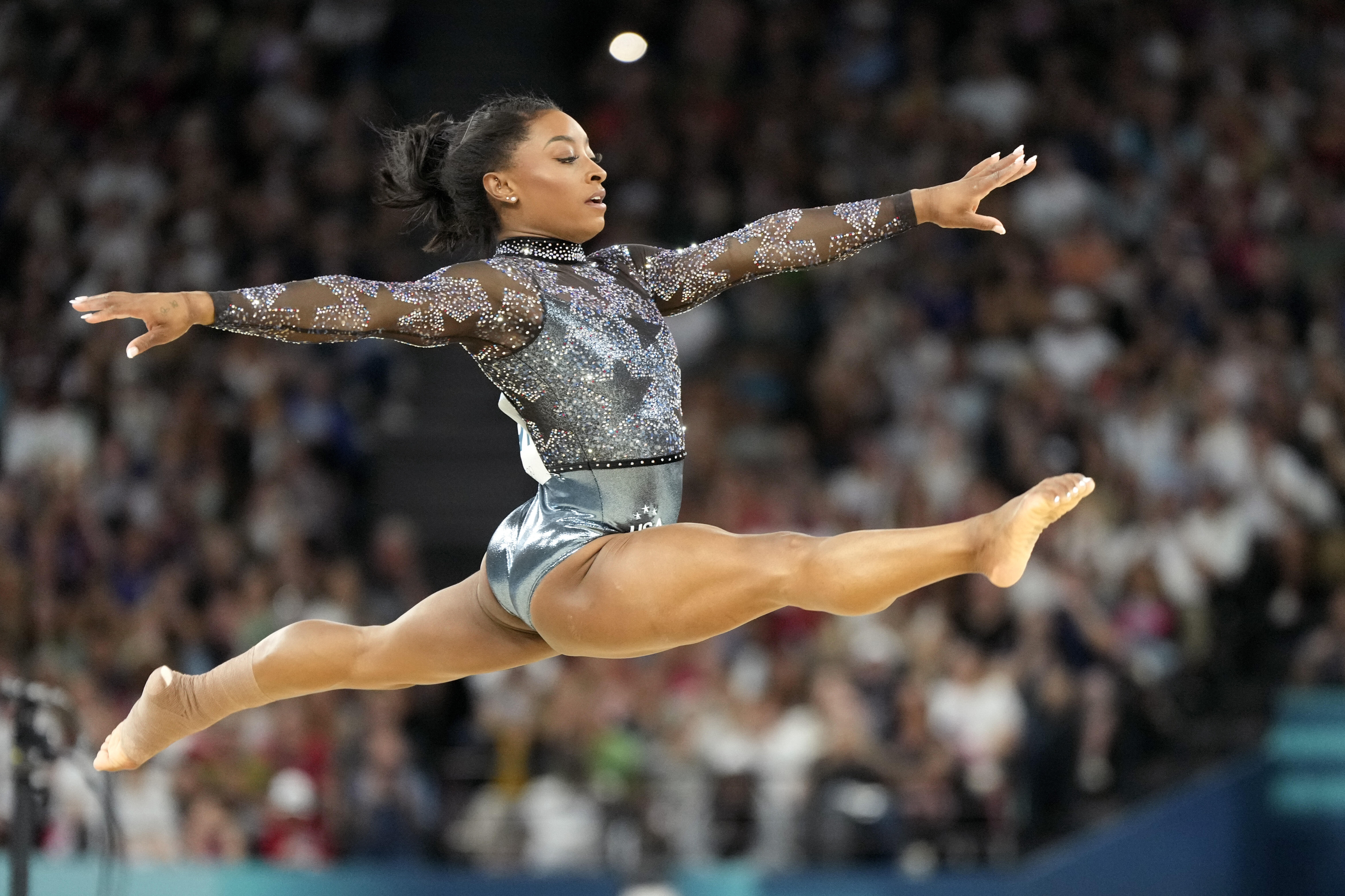 Simone Biles, of United States, competes on the floor exercise during a women's artistic gymnastics qualification round at Bercy Arena at the 2024 Summer Olympics, Sunday, July 28, 2024, in Paris, France. (AP Photo/Charlie Riedel)