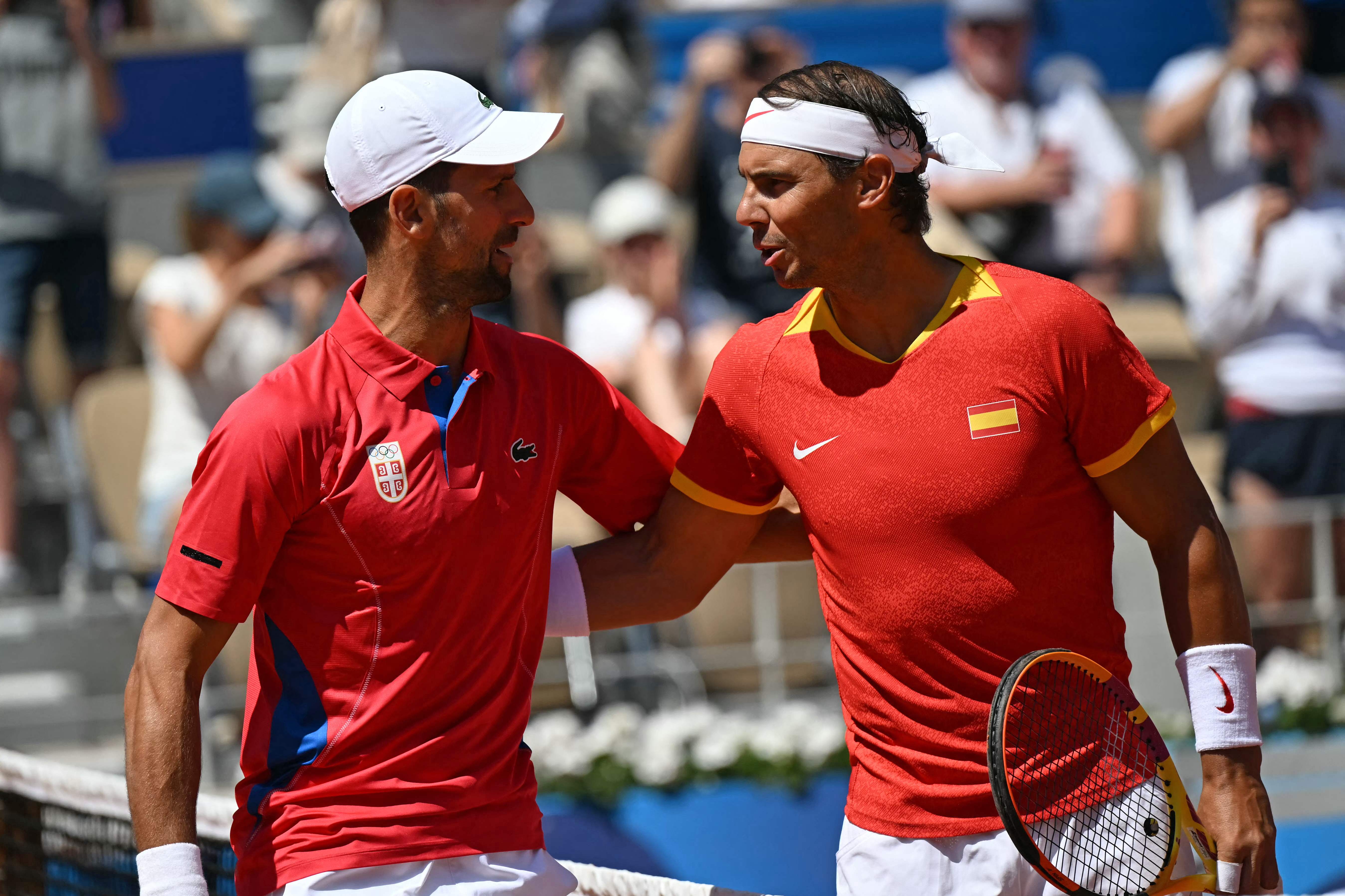 TOPSHOT - Serbia's Novak Djokovic (L) and Spain's Rafael Nadal (R) speak ahead of their men's singles second round tennis match on Court Philippe-Chatrier at the Roland-Garros Stadium at the Paris 2024 Olympic Games, in Paris on July 29, 2024. (Photo by MARTIN BERNETTI / AFP)