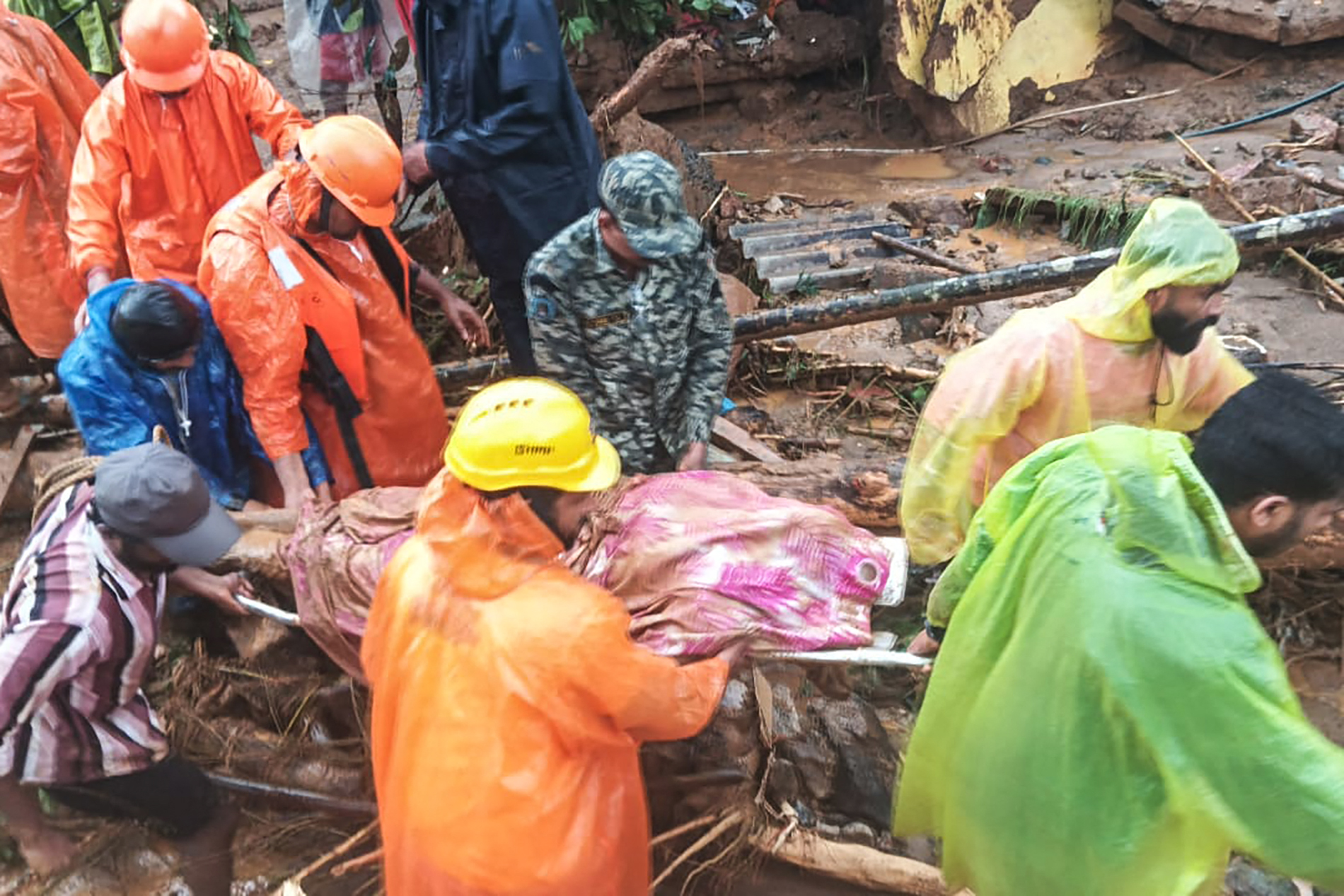 TOPSHOT - This handout photograph taken on July 30, 2024 and released by India's National Disaster Response Force (NDRF) shows NDRF personnel carrying the deceased at the disaster site as they rescue victims of the landslide in Wayanad. The southern coastal state of Kerala has been battered by torrential downpours, and the collapse of a key bridge at the disaster site in Wayanad district has hampered rescue efforts, according to local media reports. (Photo by National Disaster Response Force (NDRF) / AFP) / XGTY / RESTRICTED TO EDITORIAL USE - MANDATORY CREDIT "AFP PHOTO/India's National Disaster Response Force (NDRF)" - NO MARKETING NO ADVERTISING CAMPAIGNS - DISTRIBUTED AS A SERVICE TO CLIENTS