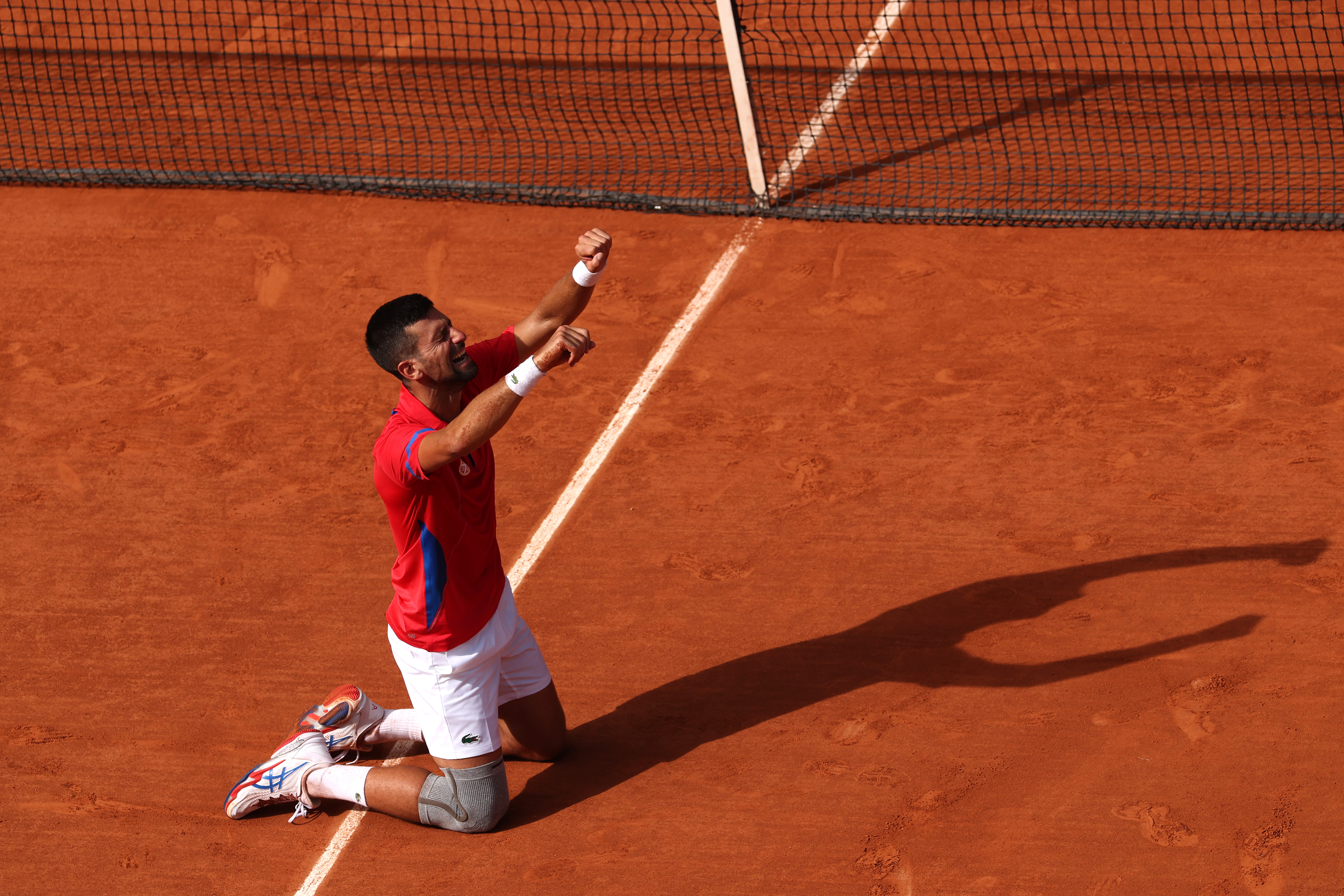 PARIS, FRANCE - AUGUST 04: Novak Djokovic of Team Serbia celebrates match point during the Men's Singles Gold medal match against Carlos Alcaraz of Team Spain on day nine of the Olympic Games Paris 2024 at Roland Garros on August 04, 2024 in Paris, France. (Photo by Matthew Stockman/Getty Images)