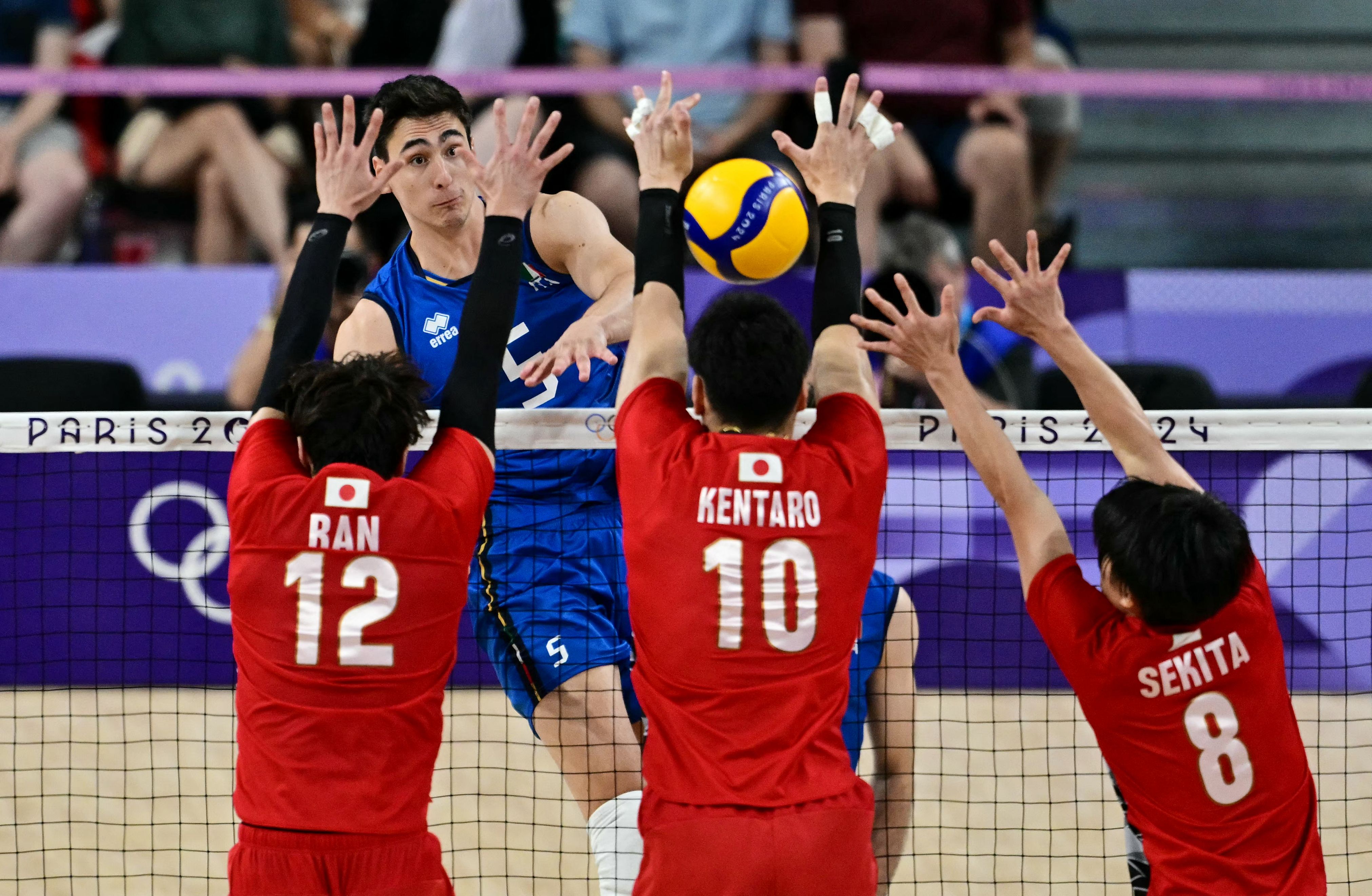 Japan's #12 Ran Takahashi, Japan's #10 Kentaro Takahashi and Japan's #08 Masahiro Sekita jump to block the ball from Italy's #05 Alessandro Michieletto (back L) during the volleyball men's quarter-final match between Italy and Japan during the Paris 2024 Olympic Games at the South Paris Arena 1 in Paris on August 5, 2024. (Photo by Miguel MEDINA / AFP)
