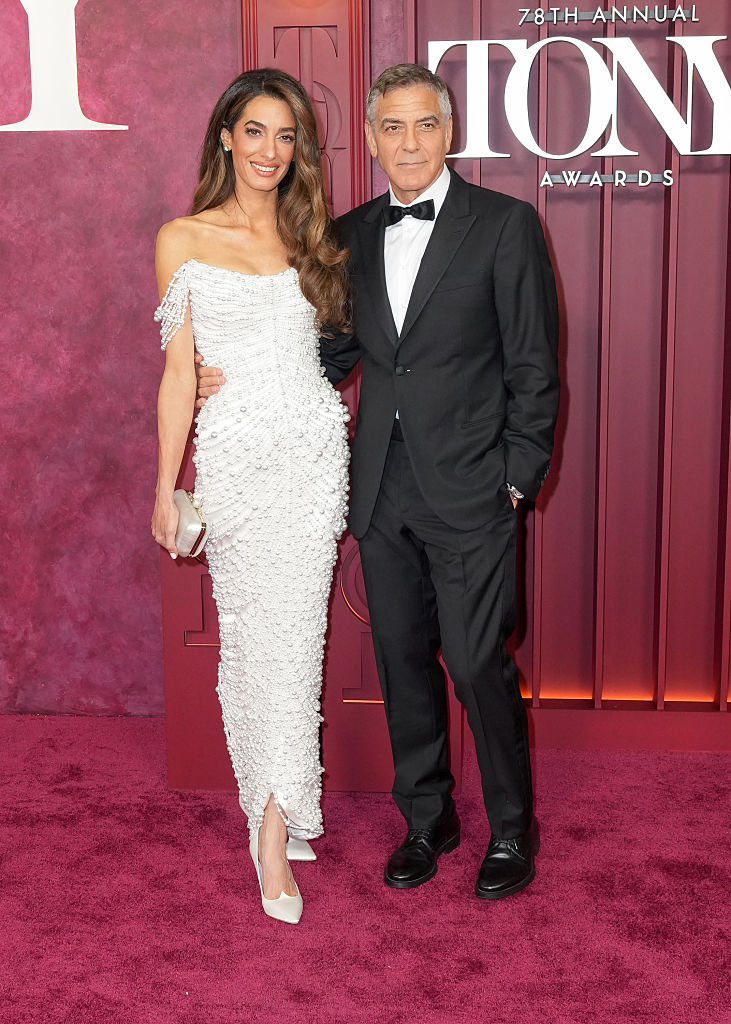 George Clooney and Amal, kiss on the red carpet. And she dresses on pearls