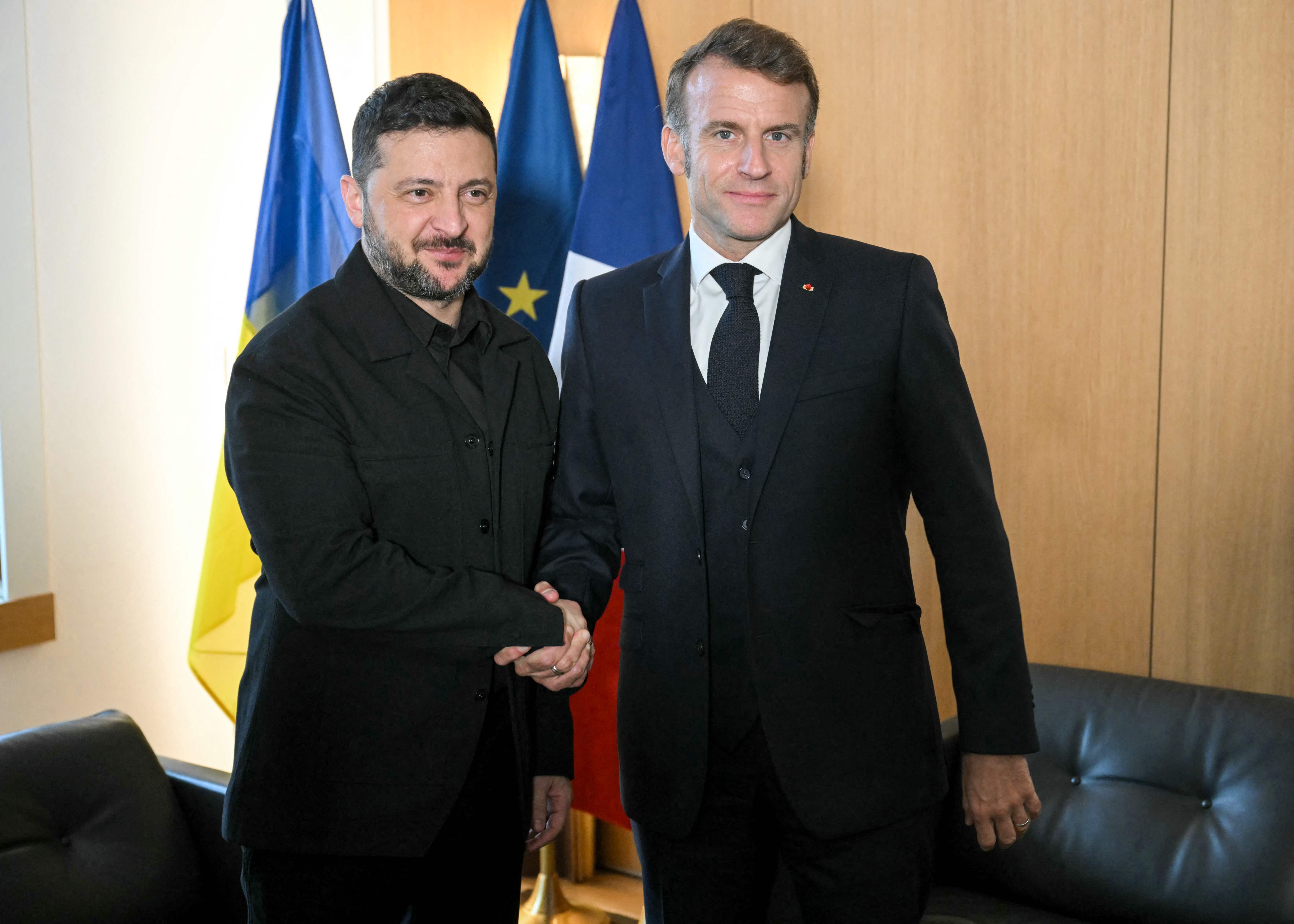 TOPSHOT - Ukraine's President Volodymyr Zelensky (L) shakes hand with France's President Emmanuel Macron (R) during a bilateral meeting on the sidelines of a European Council meeting gathering the 27 EU leaders to discuss Ukraine, European defence...